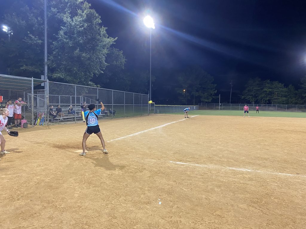 A group of people playing a softball game at night in Richmond, Virginia.