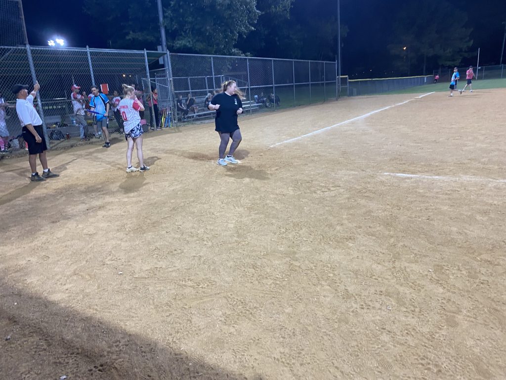 A group of people playing a game of softball at night for the RVA Softball Team Photos.