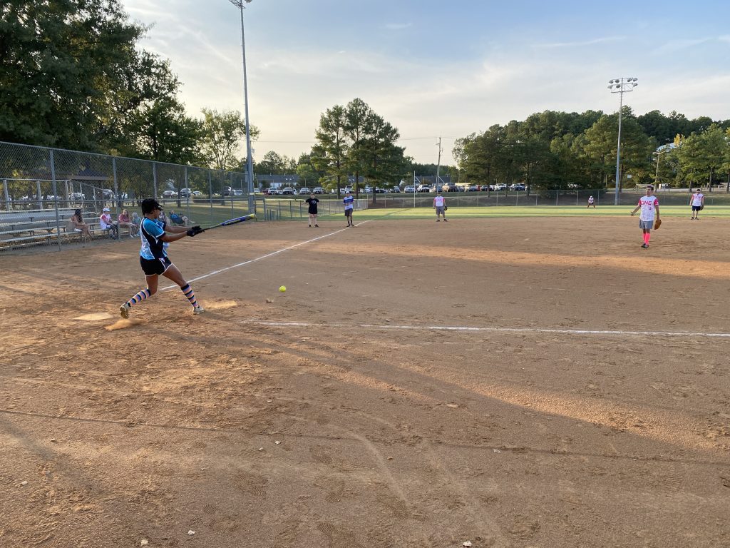 A group of girls playing softball on a field and taking NSA Softball Team Photos in Richmond, Virginia.