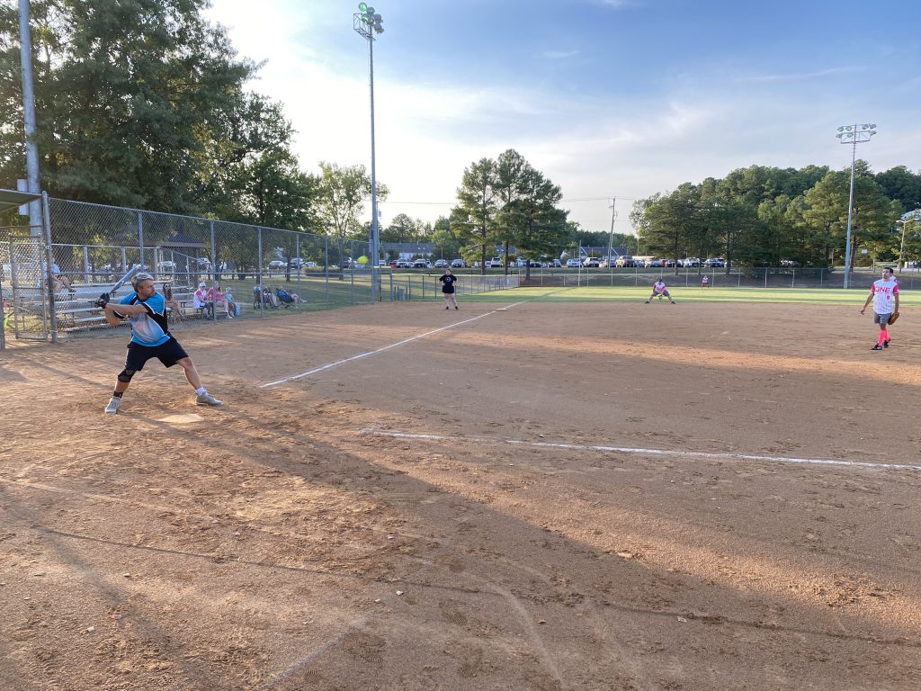 A group of people playing a game of coed softball in Richmond, Virginia.