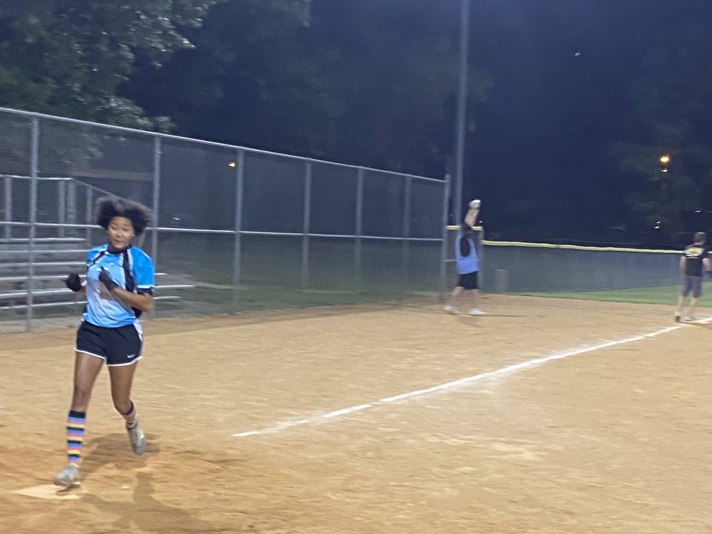 A group of girls playing softball at night in Richmond, Virginia.