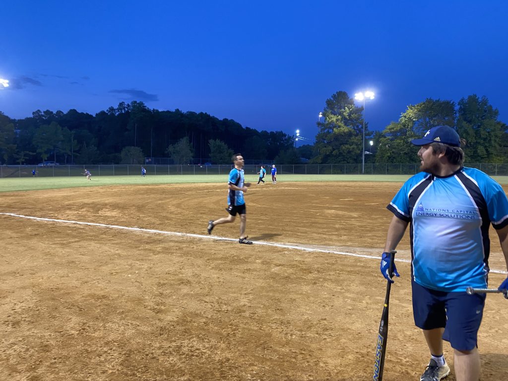 Juan holding a bat on a baseball field while another Hail Mary run comes home.