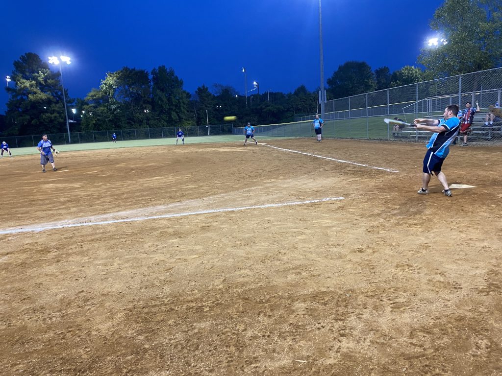 A group playing softball at night.