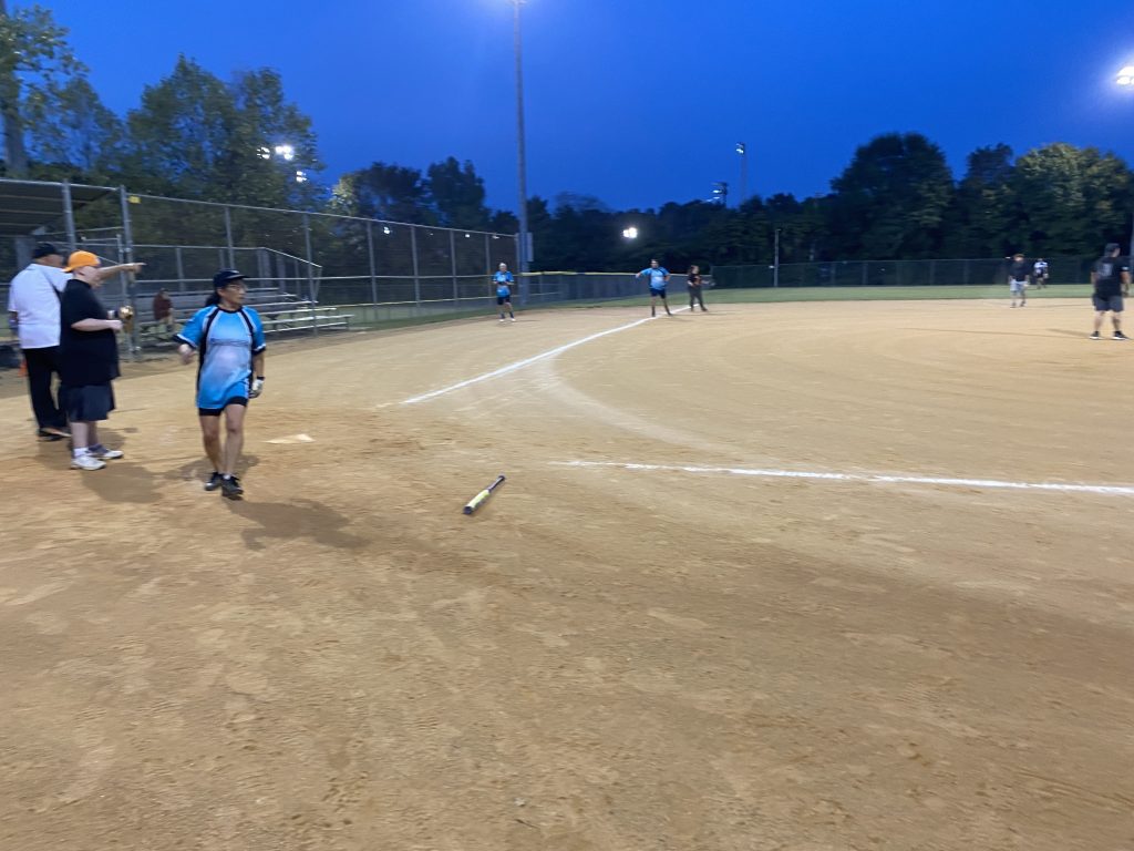 A group of people on a baseball field taking Hail Mary Softball Photos.